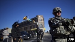 កងទ័ព​ឆ្មាំ​ការពារ​ជាតិ​ និង​ប៉ូលីស​បាល់ទីម័រ​ ក្នុង​ឈុត​សំលៀកបំពាក់​ការពារ​កុប្បកម្ម ស្ថិត​នៅ​លើ​ផ្លូវ​ពេល​ព្រឹក​ បន្ទាប់​ពី​កុប្បកម្ម​នៅ​ទូទាំង​ទីក្រុង​ បន្ទាប់​ពី​បុណ្យ​សព​របស់​លោក Freddie Gray កាល​ពី​ថ្ងៃ​ទី​២៨ ខែ​មេសា​ ឆ្នាំ​២០១៥ ក្នុង​ទីក្រុង​បាល់ទីម័រ​ រដ្ឋ​ម៉ារីឡេន។