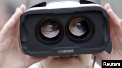 A girl wears a virtual reality headset outside the Great Hall of the People in Beijing after the opening session of the Chinese People's Political Consultative Conference (CPPCC) in Beijing, China, March 3, 2016.