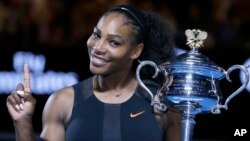 Serena Williams tenant son trophée après avoir défait sa soeur Venus, en finale de l'Open d'Australie le 28 janvier 2017