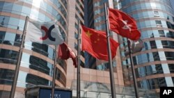 FILE - Flags are raised outside the Hong Kong Exchange Square building in Central of Hong Kong. 