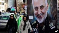Women walk past a banner of Iranian Revolutionary Guard Corps Gen. Qassem Soleimani, who was killed in Iraq in a U.S. drone attack Friday, in Tajrish Square in northern Tehran, Iran, Jan. 9, 2020.