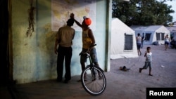 FILE - Venezuelans look at a map of the city of Boa Vista outside a gym which has turned into a shelter for Venezuelans in Boa Vista, Brazil, Nov. 18, 2017.