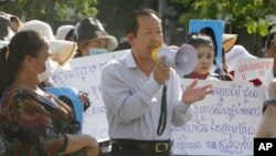 Rong Chhun, center, President of the Cambodian Trade Union Confederation, uses a megaphone during a protest near the prime minister's residence in Phnom Penh, Cambodia, Wednesday, July 29, 2020. (AP Photo/Heng Sinith)