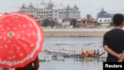 អ្នកដើេរលេងនៅ​មុខវាំង​មើលការ​ហាត់​អុំទូកប្រណាំង​​​នៅទន្លេចតុមុខ​