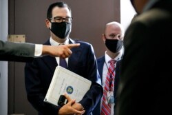 Treasury Secretary Steven Mnuchin is directed by security as he leaves a Republican luncheon while attending meetings on Capitol Hill in Washington, July 21, 2020.