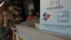 A sign for the government funded co-payment, scheme which the state picks up half hung outside a street stall in Bangkok. (Vijitra Duangdee/VOA)