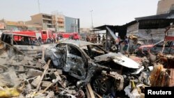 Sebuah mobil terlihat hancur akibat serangan bom di pasar Jamila, distrik Sadr City, Baghdad, Irak, 28 Agustus 2017. (Foto: REUTERS/Wissm al-Okili).