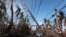Cars drive under a partially collapsed utility pole, after the island was hit by Hurricane Maria in September, in Naguabo, Puerto Rico Oct. 20, 2017.