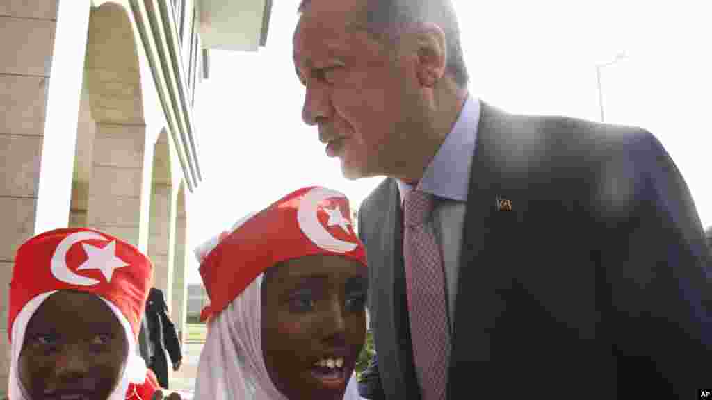 Le président Recep Tayyip Erdogan parle aux jeunes filles somaliennes qui portent des vêtements aux couleurs du drapeau turc, à Mogadiscio, 3 juin 2016.