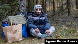 24-year-old Ali Abd Alwareth from Lebanon sits in the woods outside the emergency state zone at the Polish-Belarusian border and waits for the Border Guard patrol, October 22, 2021. 