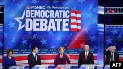Sen. Elizabeth Warren, center, speaks as Sen. Amy Klobuchar, left, South Bend, Indiana, Mayor Pete Buttigieg, former Vice President Joe Biden and Sen. Bernie Sanders, right, listen during the Democratic Presidential Debate in Atlanta, Nov. 20, 2019.