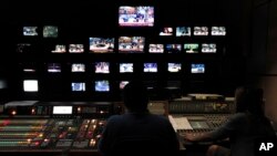 Karyawan stasiun televisi pemerintah Yunani, ERT dalam ruang kontrol di pusat stasiun televisi tersebut di Athena, 12 Juni 2013. Pemerintah Yunani mengumunkan rencana penutupan ERT dalam upaya penghematan dana, Selasa (11/6).