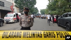 A police officer stands guard on a road leading to the police station where an explosion went off in Bandung, West Java, Indonesia, Dec. 7, 2022. 