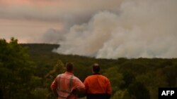 បុរសពីរនាក់កំពុងឈរមើលភ្លើងឆេះព្រៃនៅក្រុង Bargo ប្រទេសអូស្រ្តាលី កាលពីថ្ងៃទី១៩ ខែធ្នូ ឆ្នាំ២០១៩។ 