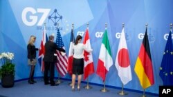 Para pekerja sedang mempersiapkan bendera negara-negara anggota G-7, saat pertemuan G-7 di Brussel, Belgia 5 Juni 2014. Menteri Luar Negeri negara-negara G-7 akan melakukan pertemuan hari Senin-Selasa ini di Tuscany Italy. (photo: AP)