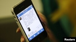 Seorang pengguna iPhone di Beijing (foto: dok). Fitur aplikasi iPhone diduga membantu pengguna mencari pekerja seks di Tiongkok. 