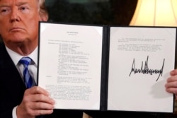 FILE - U.S. President Donald Trump holds up a proclamation declaring his intention to withdraw from the JCPOA Iran nuclear agreement after signing it in the Diplomatic Room at the White House in Washington, May 8, 2018.