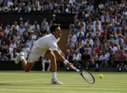 Serbia's Novak Djokovic returns the ball to Switzerland's Roger Federer during the men's singles final match of the Wimbledon Tennis Championships in London, Sunday, July 14, 2019. Djokovic won the championship.(AP Photo/Tim Ireland)