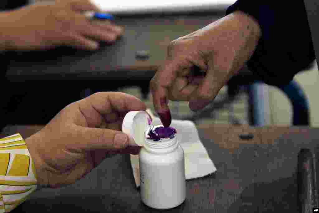An Egyptian woman inks her finger after casting her vote during the first day of the presidential election in polling center in Alexandria, Egypt, May 23, 2012. 