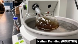 A whiskey sample made by Bespoken Spirits is placed in scientific equipment during a process designed to remove some chemicals from the liquid at the company's lab in Menlo Park, California, U.S. on December 7, 2021. (REUTERS/Nathan Frandino)