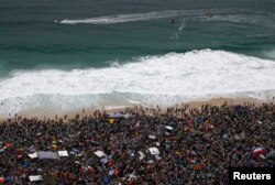 Lifeguards patrol offshore as Catholic pilgrims await the arrival of Pope Francis on Copacabana beach in Rio de Janeiro, Brazil, July 25, 2013.