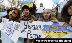 UKRAINE – Participants hold placards and shout slogans during an anti-war rally in the Crimean village of Eskisaray, outside Simferopol, March 10, 2014