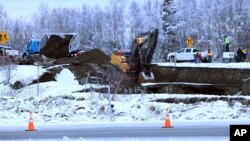 A dump truck and excavator work to repair a collapsed road in Anchorage, Alaska after an earthquake struck November 30, 2018. (AP Photo/Dan Joling)
