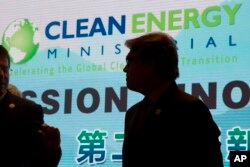 U.S. Energy Secretary Rick Perry is silhouetted near the words "Clean Energy" during a photo session after the opening ceremony of an international clean energy conference in Beijing.