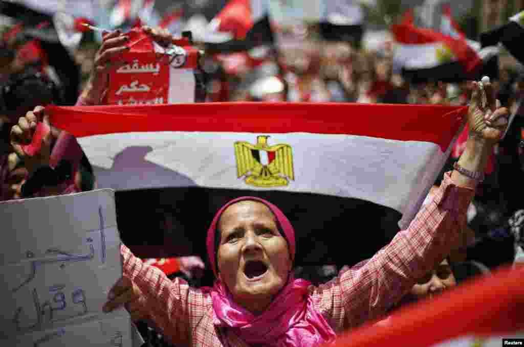A protester, opposing Egyptian President Mohamed Morsi, holds up Egypt&#39;s flag during a protest demanding that Morsi resign at Tahrir Square in Cairo, July 2, 2013. 