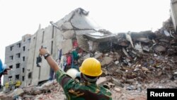 A rescue worker attempts to find survivors from the rubble of the collapsed Rana Plaza building in Savar, Bangladesh, April 30, 2013.