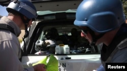 U.N. chemical weapons experts put samples collected from one of the sites of an alleged chemical weapons attack in their vehicle, in the Ain Tarma neighborhood of Damascus, Aug. 28, 2013. 