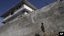 A policeman walks in front of the compound where Osama bin Laden was killed in Abbottabad, Pakistan, May 3, 2011.