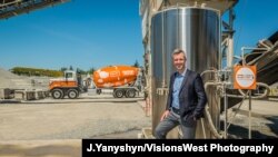 CarbonCure CEO and Founder Rob Niven standing with a CarbonCure system and branded concrete truck, April 19, 2021.