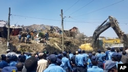 Police officers secure the perimeter at the scene of a garbage landslide, as excavators aid rescue efforts, on the outskirts of the capital Addis Ababa, Ethiopia, March 12, 2017. 