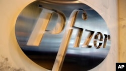 FILE - The Pfizer company logo is photographed at Pfizer Inc. headquarters, in New York, Dec. 4, 2017.