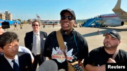 Mantan bintang basket Amerika, Dennis Rodman (tengah) tiba di bandara Pyongyang, Korea Utara, untuk kunjungan 'diplomasi bola basket' (3/9).