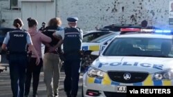 Police officers detain a man after a stabbing incident at the Countdown supermarket, in Dunedin, New Zealand, May 10, 2021 in this screen grab taken from video.