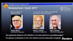 Nama Rainer Weiss, Barry C. Barish dan Kip S. Thorne ditampilkan pada layar saat KOmite Nobel mengumumkan pemenang Hadiah Nobel Fisika 2017, di Stockholm, Swedia, 3 Oktober 2017. (Foto: dok).