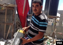 Anwar Mohammed holds part of a rocket that destroyed his family's home in Gaza during Israel's Operation Protective Edge targeting Palestinian militants. (VOA / Gabe Joselow)