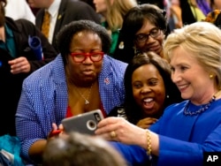 FILE - Democratic presidential candidate Hillary Clinton takes pictures with supporters after a campaign event at the Central Baptist Church in Columbia, S.C., Feb. 23, 2016, during a primary season that has proved surprisingly competitive.