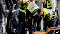 Israeli emergency services officers evacuate the body of a Palestinian assailant form the site outside Jerusalem’s Old City, Dec. 23, 2015.