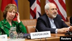 FILE: European Union foreign policy chief Catherine Ashton, left, and Iranian Foreign Minister Mohammad Javad Zarif smile at the start of nuclear talks in Vienna April 8, 2014. 