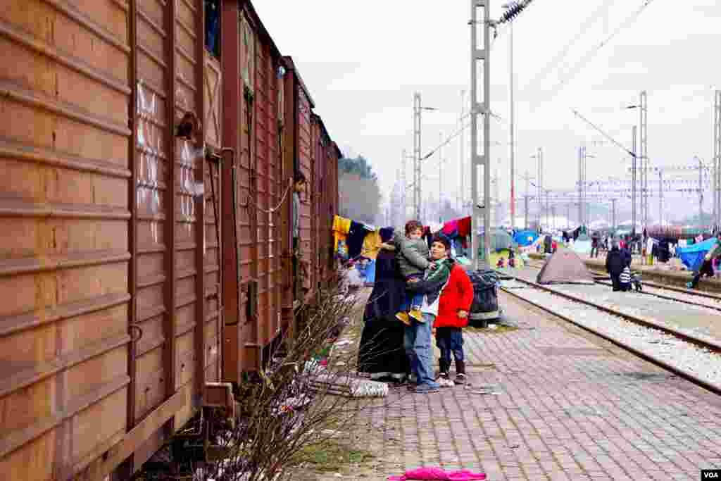 A refugee family leaves their temporary home to join the food distribution lines. (Jamie Dettmer for VOA) 