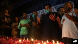 People attend a candlelight vigil for victims of the Friday crash of a state-run Pakistan International Airlines plane, in Karachi, Pakistan, May 27, 2020.