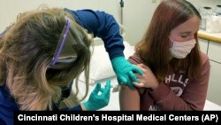  Clinical research coordinator Tammy Lewis-McCauley administers an injection to Katelyn Evans, a trial participant, as part of the hospital’s clinical trial of Pfizer's COVID-19 vaccine at Cincinnati Children’s Hospital Medical Center on Wednesday, Oct. 1