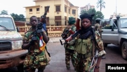 Fighters for the Seleka rebel alliance stand guard in front of the presidential palace in Bangui, Central African Republic, March 25, 2013.