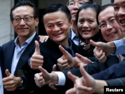 Alibaba Group Holding Ltd founder Jack Ma (2nd L) poses as he arrives at the New York Stock Exchange for his company's initial public offering (IPO) under the ticker "BABA" in New York Sept. 19, 2014.