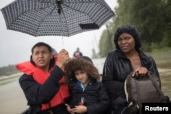 Residents are rescued by a boat from rising flood waters from Tropical Storm Harvey in east Houston, Texas, Aug. 28, 2017.