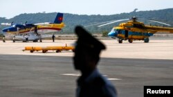 មន្ត្រី​​វៀតណាម​មួយ​រូប​​ឈរ​យាម​នៅ​ជិត​យន្តហោះ​ឯ​អាកាសយានដ្ឋាន​លើ​កោះ​ត្រល់ (Phu Quoc) កាល​ពី​ថ្ងៃ ១០ មីនា ២០១៤ ​​នៅ​មុន​បេសកកម្ម​ស្វែង​រក​យន្តហោះ​​ម៉ាឡេស៊ី​​​ MH370 ដែល​បាត់។