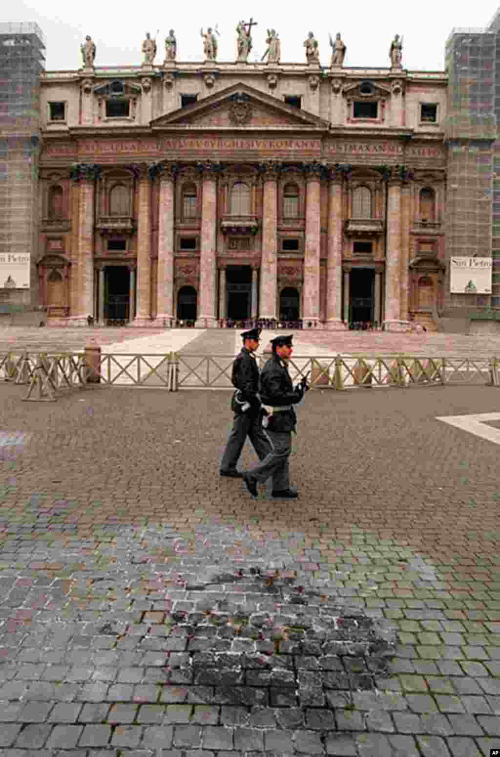 Police pass the area in St. Peter's Square where a Sicilian man, opposed to the Vatican's ban on homosexual relations, set himself on fire January 13. Alfredo Ormando, 39, from Palermo, doused himself with petrol and set himself alight, then attempted to 
